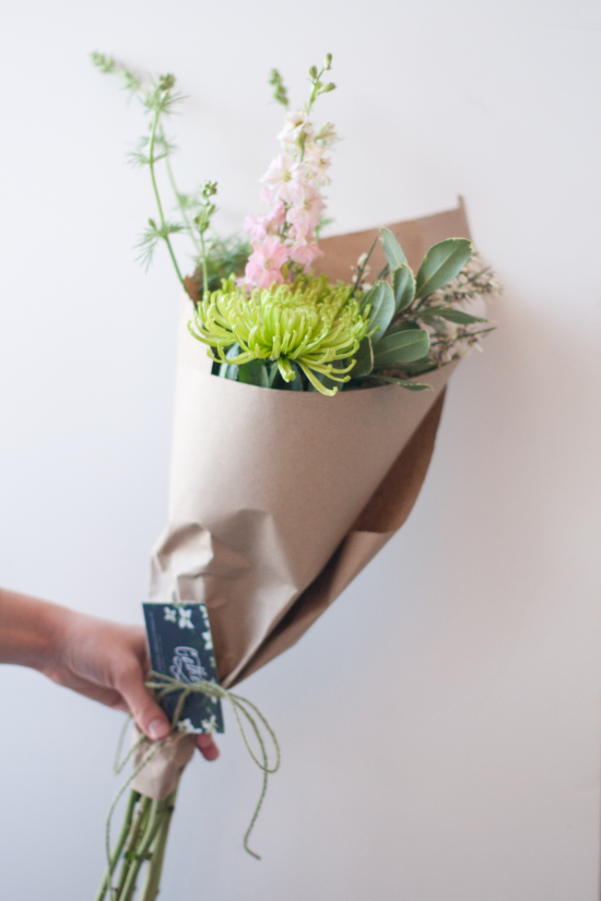 Cut Flowers Wrapped in Kraft Waxed Tissue Paper and Tied with Olive Green Twine with a Business Card Tucked In | Gather Goods
